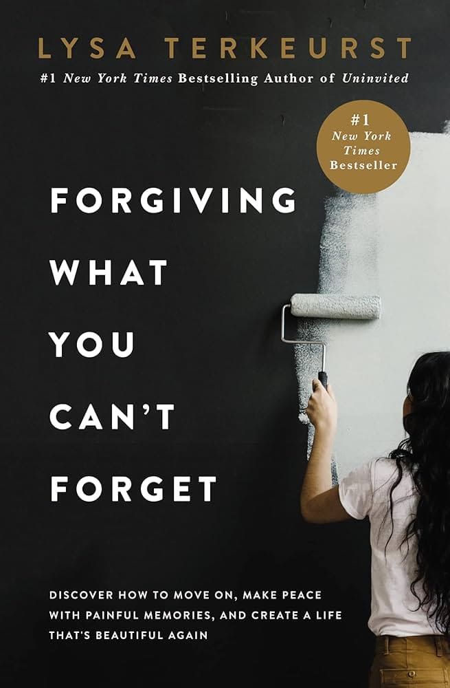 A woman paints a black wall white with a roller, symbolizing forgiveness and letting go. Large white text reads: "Forgiving What You Can't Forget" by Lysa TerKeurst—a #1 New York Times bestseller on emotional healing.